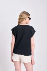 Camiseta negra de manga corta con cuello redondo y bordes deshilachados en las mangas.