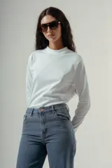 Camiseta de manga larga con cuello redondo, confeccionada en algodón, con un patrón de rayas horizontales blancas y marrones. Presenta un pequeño logo bordado en color rojo en el pecho.