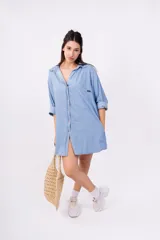 Camisa celeste de mangas largas con puños abotonados, cuello clásico y cierre frontal con botones.