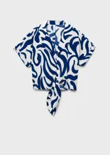 Camisa de viscosa blanca con estampado abstracto en azul, corte crop, cuello camisero, mangas cortas y nudo decorativo en el frente.