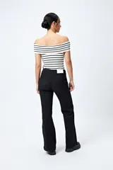 Pantalón de jean azul oscuro, de corte flare con cinturón incorporado en la misma tela y silueta ajustada en cadera que se ensancha hacia el ruedo.