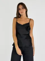 Top negro de breteles finos con escote drapeado y detalle de flor en el pecho.