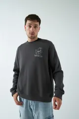 Buzo marrón de felpa con cuello redondo, puños y cintura acanalados. Estampa pequeña en el frente y grande en la espalda con diseño floral y texto.