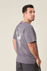 Remera marrón de corte holgado con estampado de un ave y texto en la espalda.