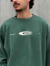 Buzo verde con logo 'OSTEN' estampado en el pecho.