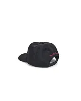 Gorro negro con visera, con bordado frontal de la marca Deus Ex Machina en color celeste con contorno rosa.