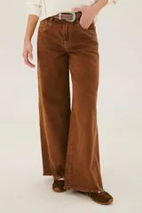 Pantalón de jean acampanado color caramelo con cintura alta y cinturón marrón con tachas.