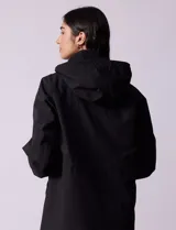 Gabardina negra impermeable con capucha desmontable, cierre central con cremallera y botones a presión, bolsillos delanteros y forro interno.