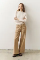 Pantalón de pierna ancha color beige, con bolsillos laterales y pespuntes marcados.