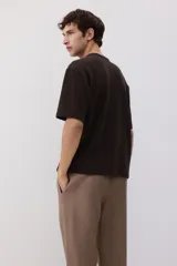Pantalón marrón claro de lino, corte recto, con cintura elástica y cordón ajustable. Posee bolsillos laterales y trasero.