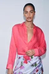 Camisa color fucsia con textura de rayas tejidas, de cuello solapa y manga larga. Cierre frontal con botones.