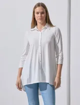 Camisola blanca de manga tres cuartos, marca Rio & Rian. Cuello con solapa y abertura central con botones. Manga con detalle fruncido.