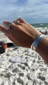 Pulsera tipo esclava abierta, con acabado rústico y textura irregular, en tono plateado. Se vende por unidad.