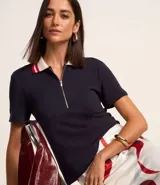 Blusa azul marino de viscosa con cuello polo blanco con detalles en rojo y cierre de cremallera.