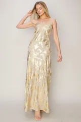 Vestido largo de fiesta color champagne con estampado dorado, breteles finos y escote en V.