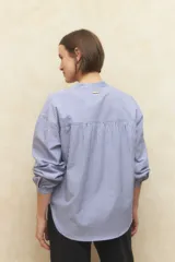Blusa de manga larga a rayas azul con cuello mao, escote en V y lazos en los puños.
