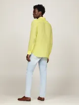 Camisa de lino color amarillo claro, de corte regular, cuello abotonado y manga larga.