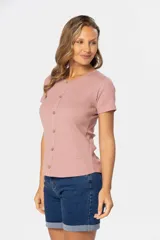 Remera color rosa con textura acanalada, cuello redondo y botones frontales.