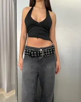 Cinturón negro de cuero sintético con hebilla metálica plateada y ojalillos metálicos plateados.