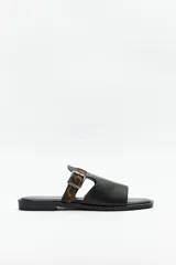 Sandalias bajas negras con suela acolchonada y taco de 2cm. Capellada de símil cuero texturizado con tira en animal print y hebilla ajustable.