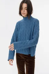 Sweater color beige con diseño de trenzado y cuello alto, de corte holgado.