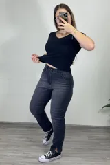 Pantalón jean gris oscuro, corte mom, tiro alto, con tajo en el ruedo.