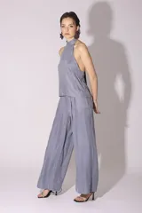 Conjunto de pantalón y top de seda color gris, con cuello halter y corte holgado.