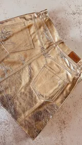Minifalda dorada de cuero ovino italiano con terminación "rota".