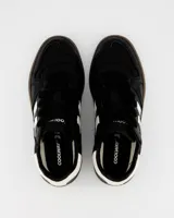 Championes urbanos Coolway modelo Goal, color negro con detalles en blanco y marrón. Confeccionados en cuero suave con puntera reforzada, cordones planos de algodón bicolor intercambiables y suela flexible de goma y caucho.