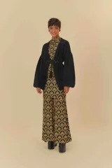 Pantalón acampanado negro con estampado floral dorado, de tiro alto y cintura elástica.