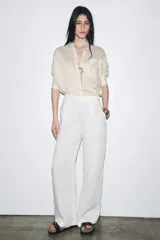Camisa de manga larga con cuello solapa, a rayas verticales grises y blancas. Tiene un bolsillo de plastrón en el delantero y cierre frontal con botones.
