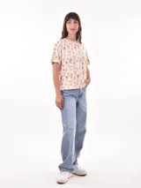 Remera de manga corta con estampado abstracto en tonos beige, negro y blanco.