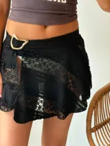 Minifalda negra de encaje con forro interior y cinturón con hebilla dorada.