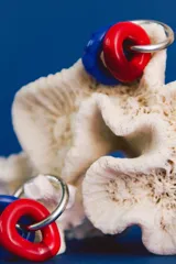 Aros colgantes hechos a mano con cuentas de cristal de Murano rojas y azules, unidas por un aro de acero quirúrgico.