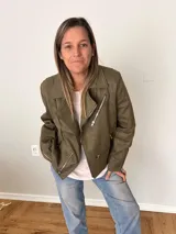 Campera biker verde oliva de gamuza sintética suave, con cierre asimétrico metálico, bolsillos y mangas con cremalleras.