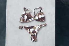 Conjunto de bikini turquesa con corpiño triangular de corte fijo, breteles regulables y almohadillas desmontables, y bombacha vedetina con frunce elástico en los costados.