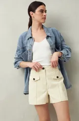 Short blanco de tiro alto con bolsillos delanteros con solapa y botones a la vista.