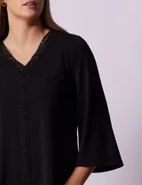 Blusa negra de seda fría, marca Rio & Rian, con escote en V y aplique de crochet en la parte delantera.