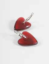 Aros colgantes con dije de corazón de cristal rojo translúcido y ganchos tipo argolla plateados.
