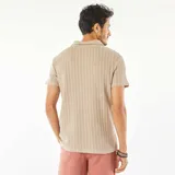 Remera polo de manga corta color beige, de punto gofrado con textura acanalada vertical.