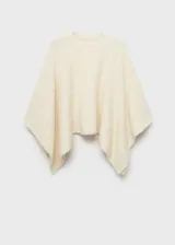 Poncho de punto color crudo, con cuello redondo y bajo asimétrico. Tejido con lana, poliéster y acrílico.