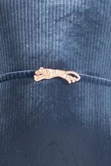 Malla entera azul de terciopelo con textura acanalada, escote cuadrado, breteles anchos y cinturón con hebilla dorada en forma de tigre.