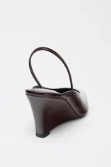 Zapato destalonado color marrón oscuro con tacón de cuña y tira trasera elástica.