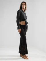 Camisa negra de manga larga con lazo en la cintura y botones nacarados. Confeccionada en 100% algodón y detalle de Polonio en cobre.