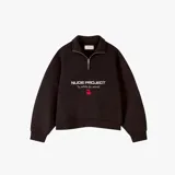 Buzo negro de corte holgado con cierre metálico en el cuello, con el logo de la marca Nude Project y cerezas estampadas en el frente.