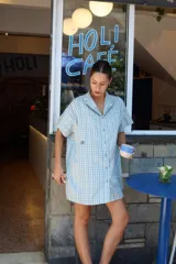 Vestido corto camisero a cuadros celestes y blancos, de corte amplio y cuello mao. Tiene botones a tono y logo bordado en el frente.