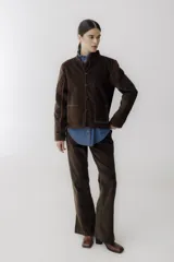 Pantalón de pana marrón con corte acampanado y abertura en el ruedo.