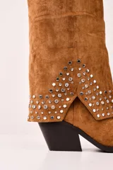 Bota texana de caña alta color camel, con detalles de tachas plateadas en el tobillo, hebilla decorativa y taco cuadrado.