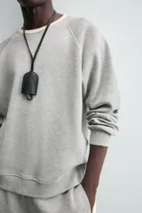 Sudadera gris de tejido compacto con mezcla de algodón y viscosa, corte relaxed fit, cuello redondo con rib combinado a contraste, manga larga y acabados en rib.