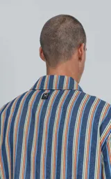 Camisa de manga corta con cuello cubano y estampado a rayas verticales en tonos azul, amarillo y rojo.